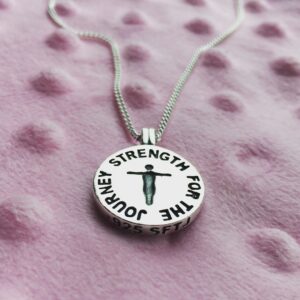 Traveling Pendant necklace on a pink blanket